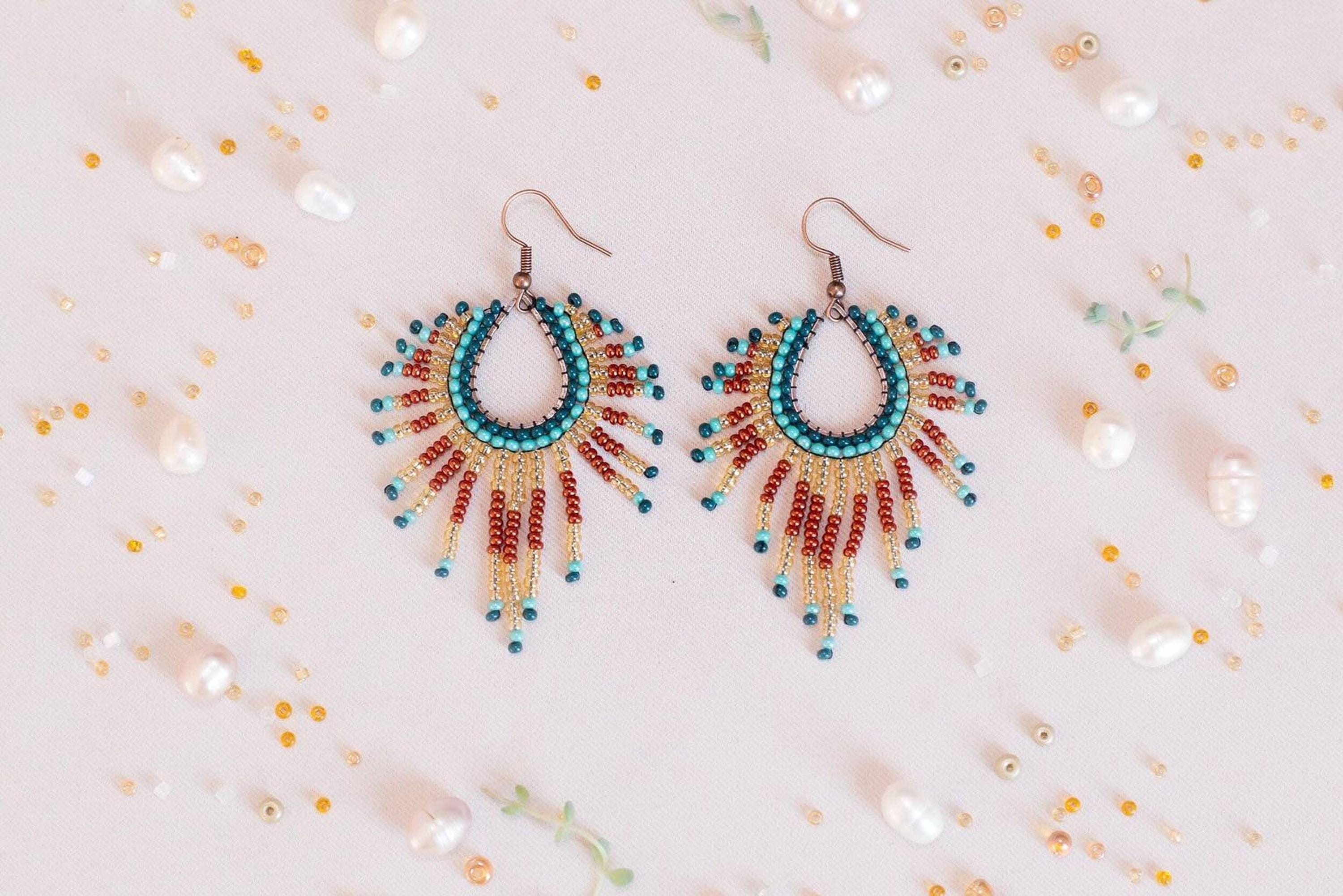 a pair of colorful beaded earrings sitting on top of a table